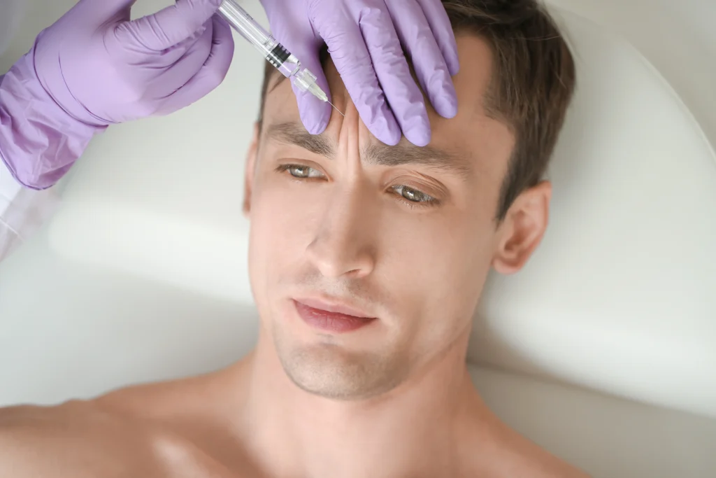 A man receiving a Botox injection on his forehead.