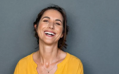 Smiling woman with smooth skin wearing a yellow top.