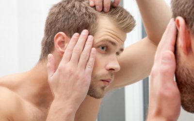 Male model looking in the mirror at his hair