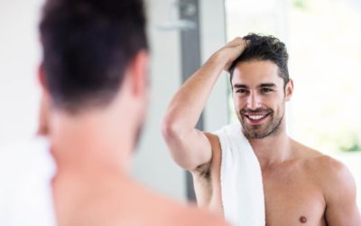Male model looking at himself in the mirror shirtless