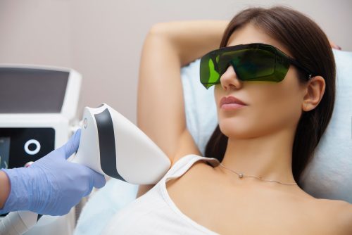 Woman receiving laser hair removal treatment from a professional.