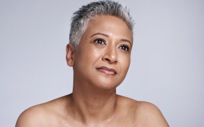 Senior woman with short gray hair enjoying skincare and wellness, showcasing natural beauty with a serene expression.