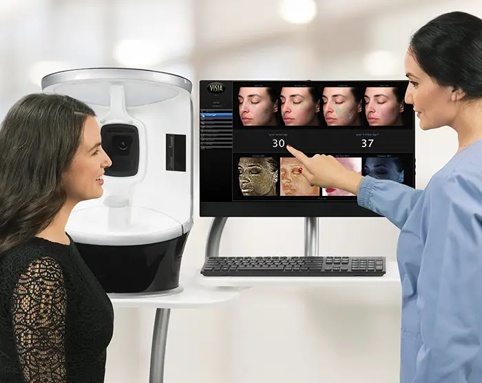 Advanced Skin Analysis at Miami Dermatology Center Aesthetician consults with a woman using advanced skin analysis technology at a dermatology center.