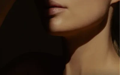 Elegant woman with radiant skin, partially shaded face highlighting smooth complexion.