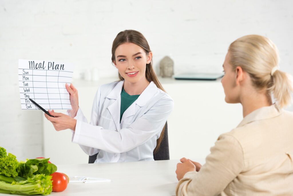 Nutritionist showing weekly meal plan chart
