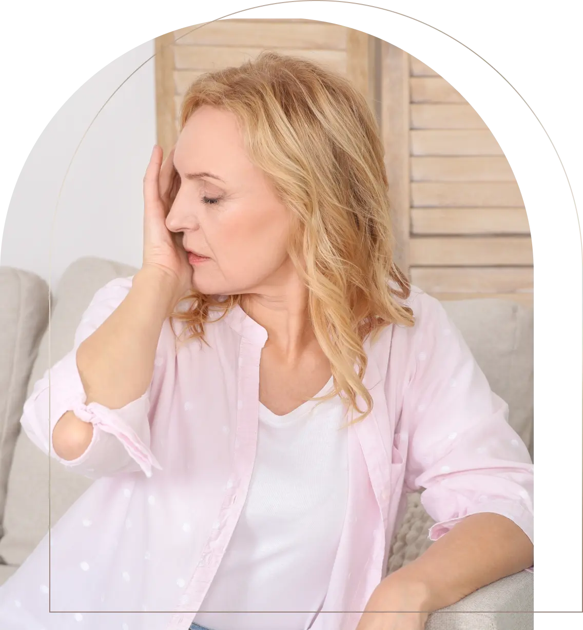 Woman holding cheek in pain on couch