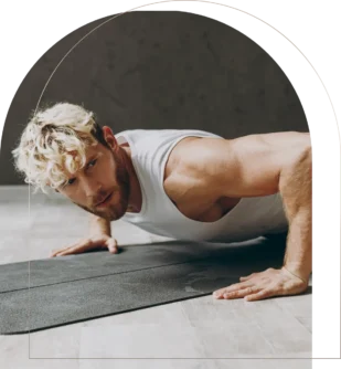 Muscular man doing push-ups on black exercise mat indoors Man doing push-ups on exercise mat