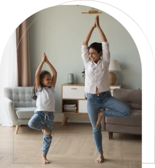 Mother and daughter doing yoga tree pose