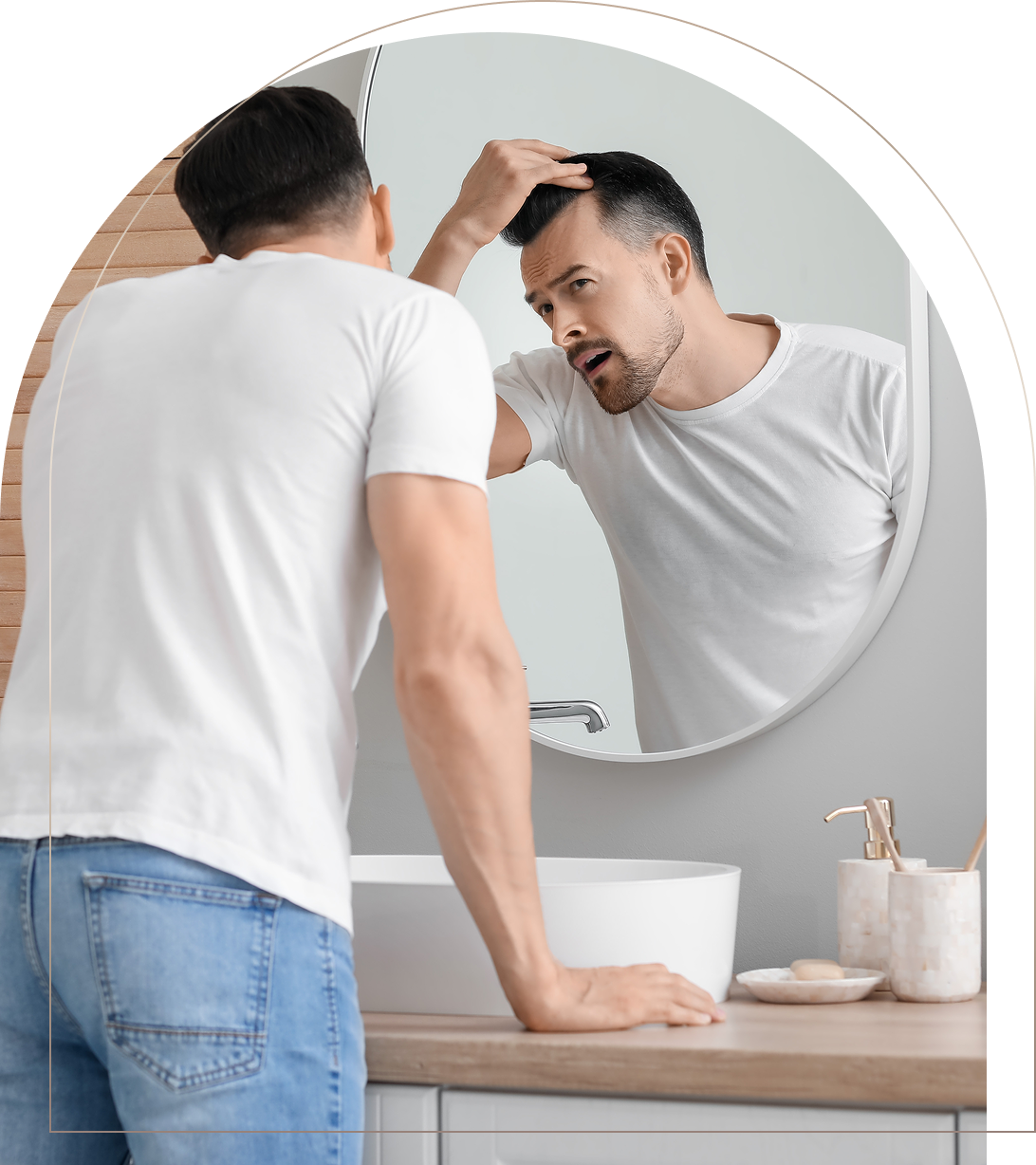Man checking hairline in bathroom mirror