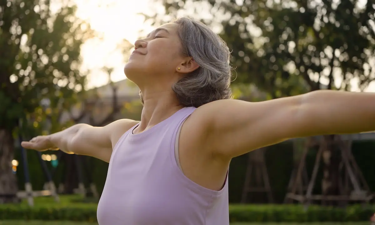 Woman stretching arms outdoors in park